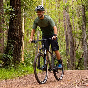 Man riding a bike through the woods